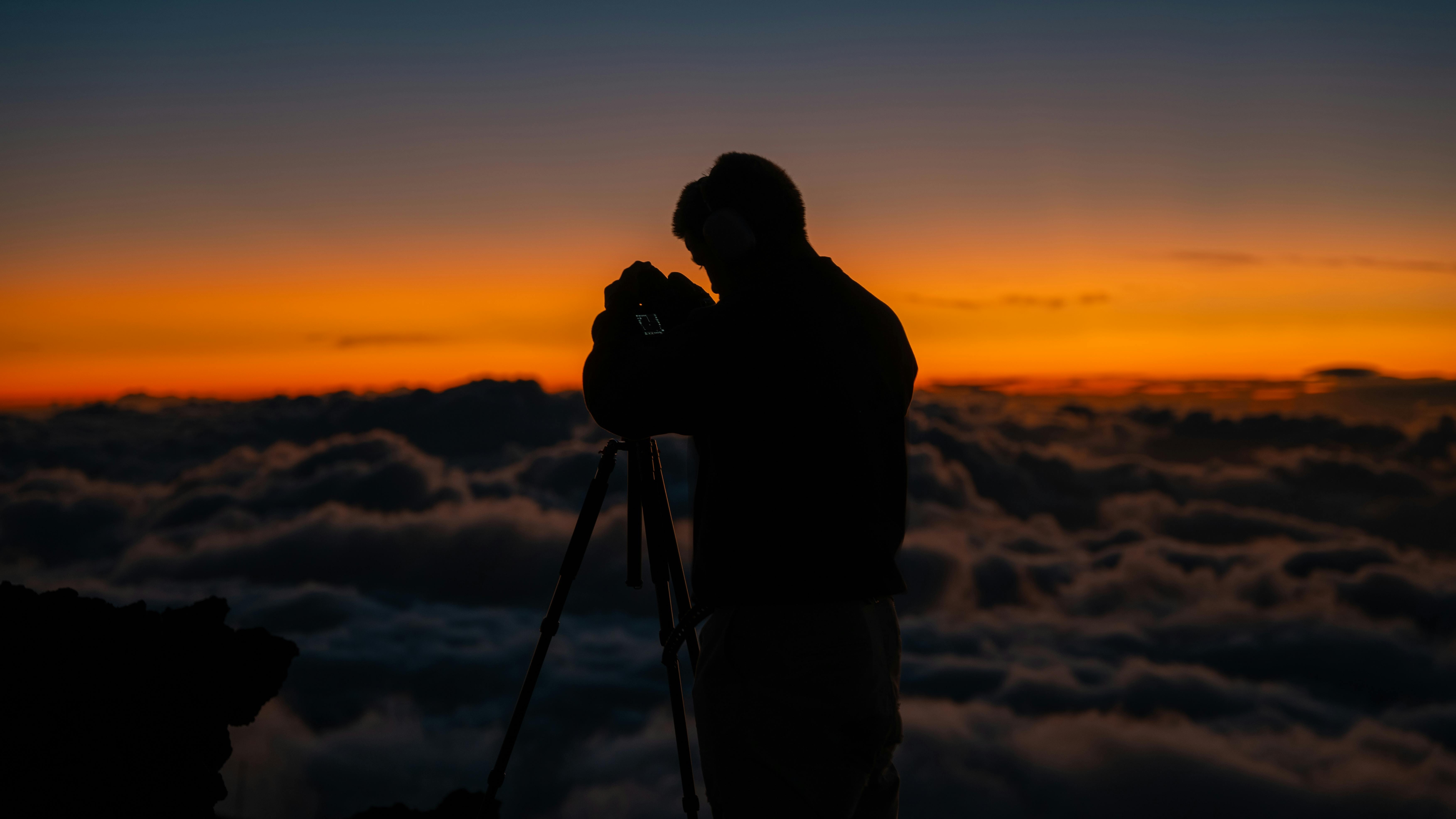 Professional photographer with camera on tripod shooting outdoors